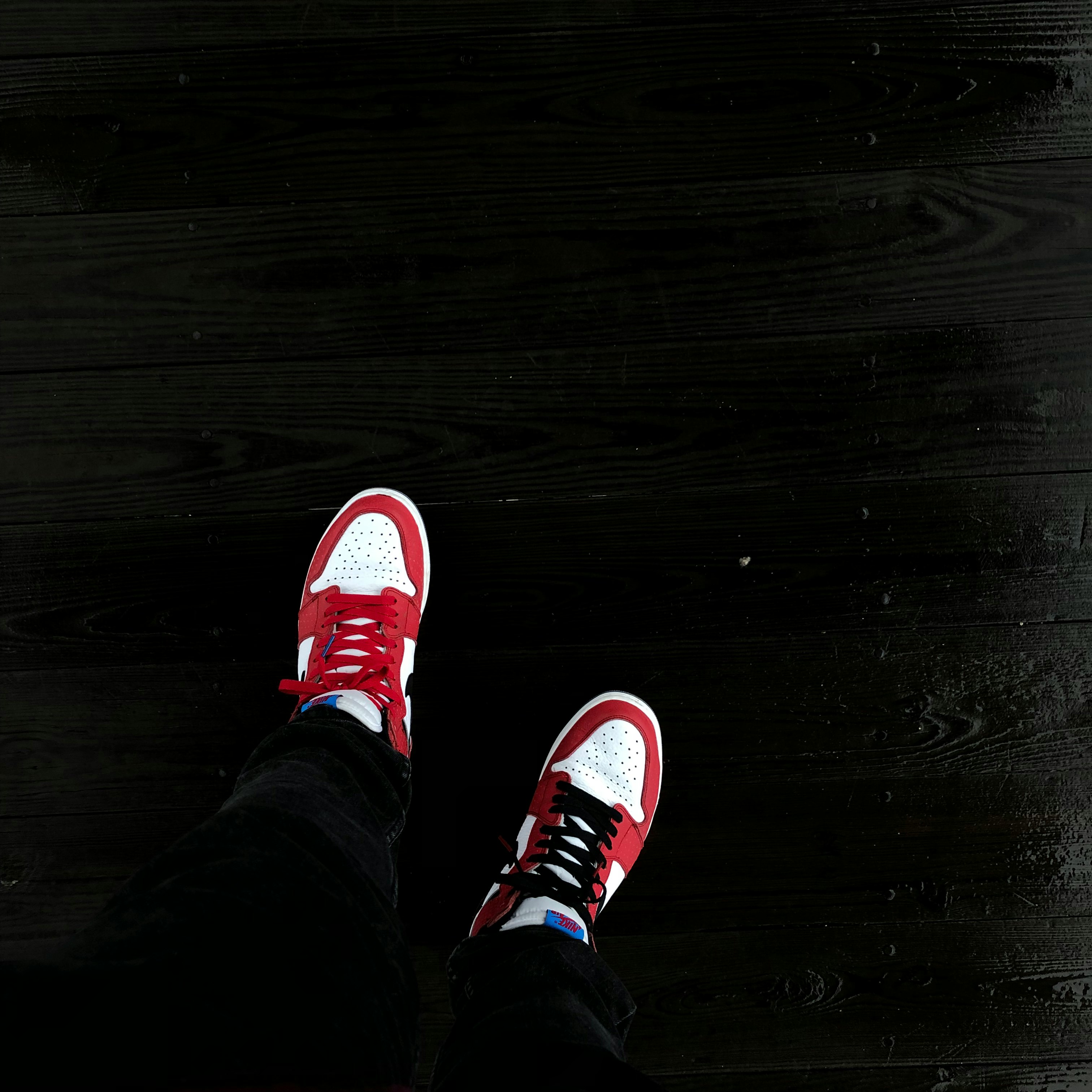 person in black pants and red sneakers